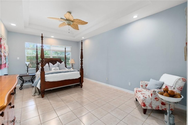 tiled bedroom with a tray ceiling and ceiling fan