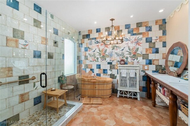 bathroom with sink, tile walls, tile patterned flooring, an enclosed shower, and an inviting chandelier