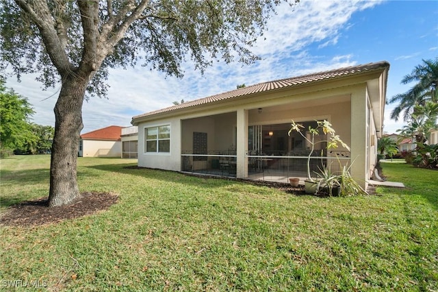 rear view of house featuring a yard