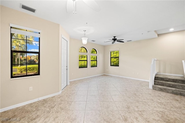 tiled spare room featuring plenty of natural light and ceiling fan