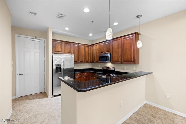 kitchen with dark stone counters, light tile patterned floors, kitchen peninsula, pendant lighting, and stainless steel appliances