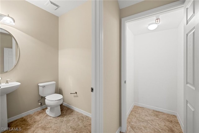 bathroom with sink, toilet, and tile patterned floors