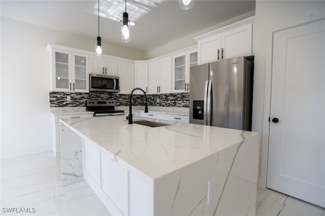 kitchen featuring pendant lighting, sink, a kitchen island with sink, stainless steel appliances, and light stone counters