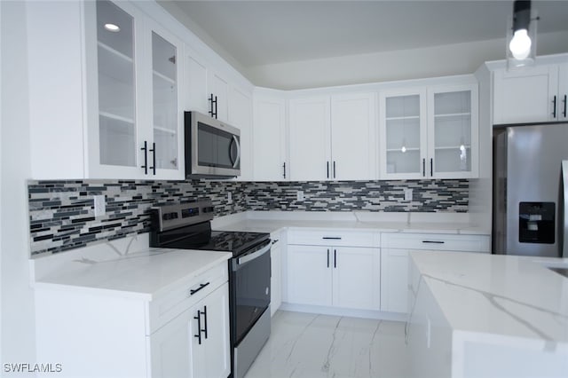 kitchen featuring light stone counters, decorative light fixtures, stainless steel appliances, decorative backsplash, and white cabinets