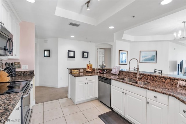 kitchen with a sink, stainless steel appliances, a raised ceiling, and visible vents