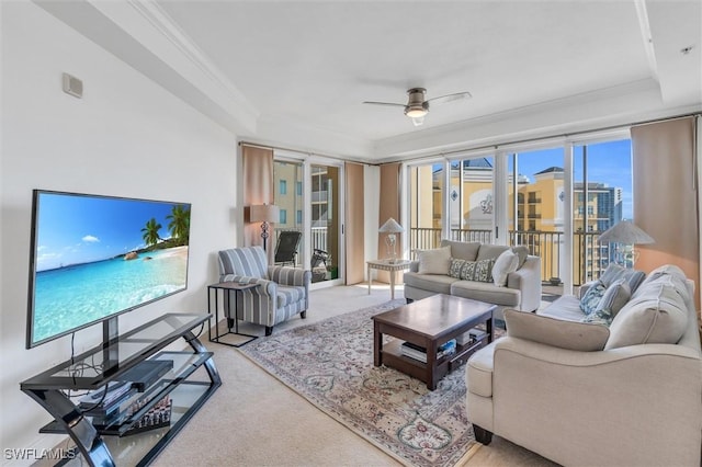 living room featuring ceiling fan, light colored carpet, and crown molding