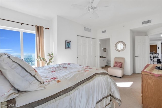 bedroom with connected bathroom, a closet, access to outside, ceiling fan, and light colored carpet