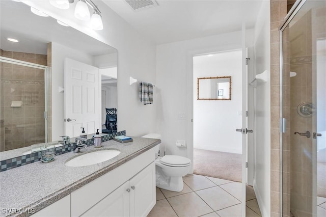 bathroom with toilet, tile patterned flooring, walk in shower, and vanity