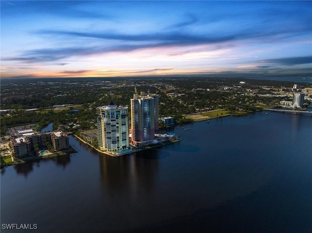 aerial view at dusk featuring a water view