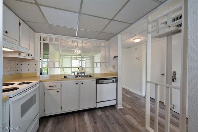 kitchen featuring white appliances, a paneled ceiling, white cabinetry, decorative backsplash, and sink