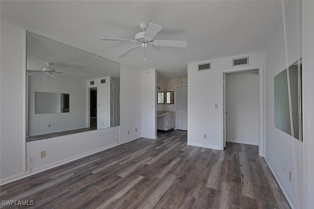 unfurnished living room featuring a textured ceiling, ceiling fan, and dark hardwood / wood-style flooring