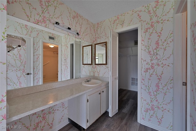 bathroom featuring hardwood / wood-style flooring, a textured ceiling, and vanity