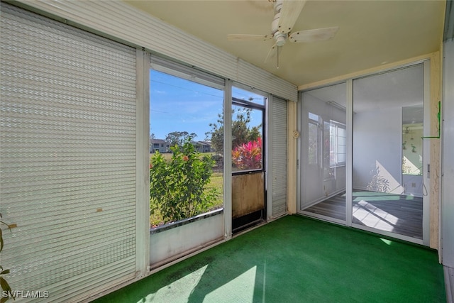 unfurnished sunroom with ceiling fan