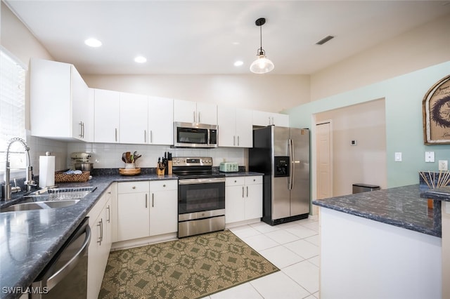 kitchen with pendant lighting, sink, lofted ceiling, stainless steel appliances, and white cabinets