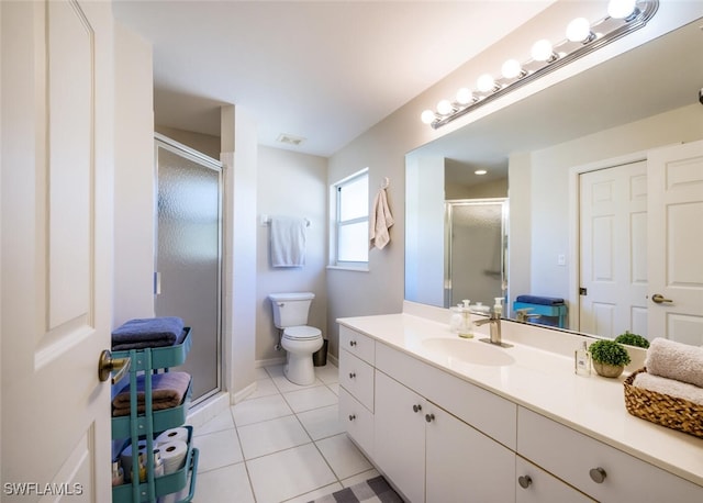 bathroom with vanity, toilet, a shower with shower door, and tile patterned flooring