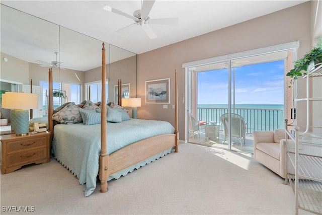 bedroom featuring carpet floors, a water view, ceiling fan, and access to outside