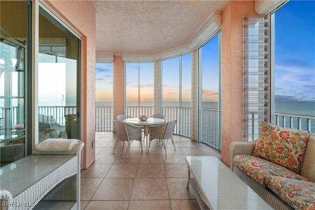 sunroom featuring a water view