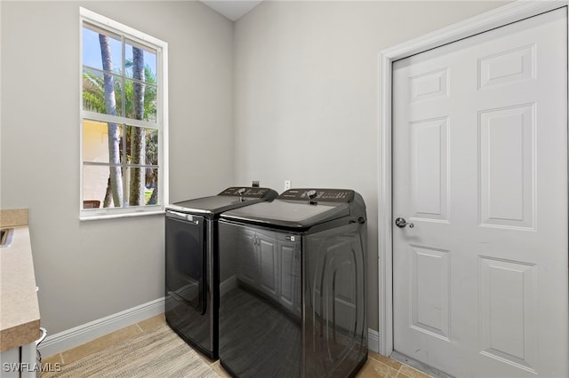 laundry room featuring separate washer and dryer and light tile patterned flooring