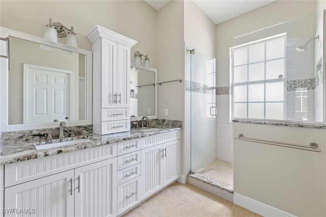 bathroom with plenty of natural light, tile patterned floors, walk in shower, and vanity