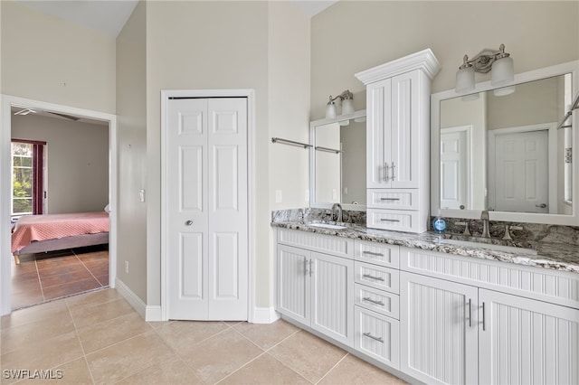 bathroom with tile patterned floors, a towering ceiling, and vanity