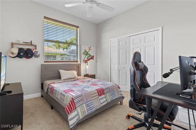 bedroom with ceiling fan, light colored carpet, and a closet