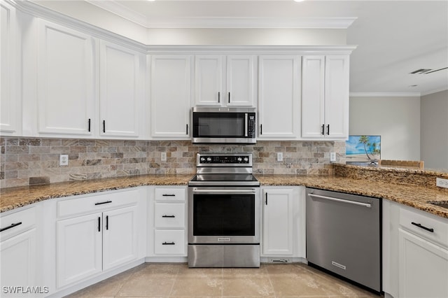 kitchen featuring stainless steel appliances, dark stone countertops, backsplash, and white cabinetry