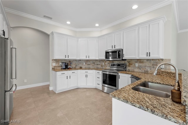 kitchen with tasteful backsplash, sink, appliances with stainless steel finishes, white cabinets, and light stone counters