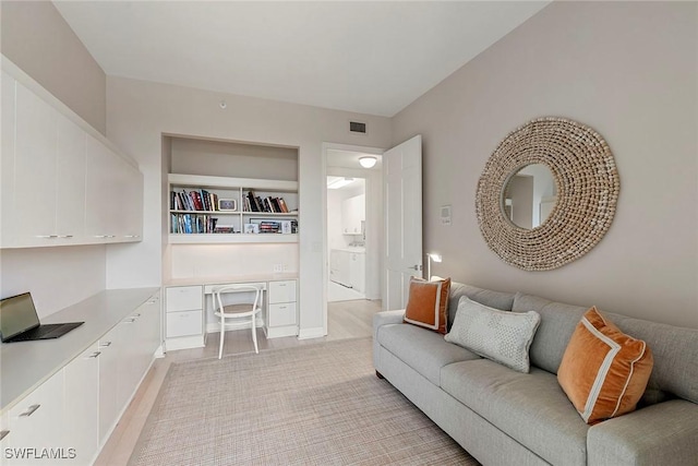 living room featuring light wood-type flooring and built in desk