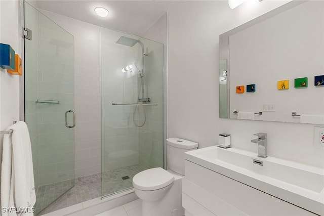 bathroom with a shower with shower door, tile patterned floors, toilet, and vanity