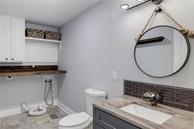 bathroom with tasteful backsplash, vanity, and toilet