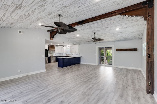 unfurnished living room featuring lofted ceiling with beams, ceiling fan, sink, and light hardwood / wood-style floors