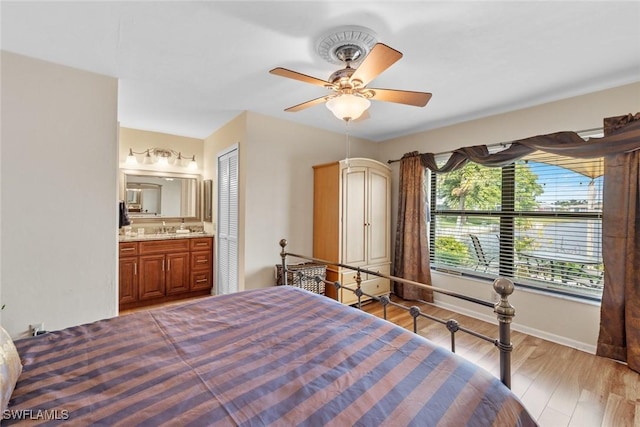 bedroom featuring a closet, ensuite bath, ceiling fan, and light hardwood / wood-style flooring