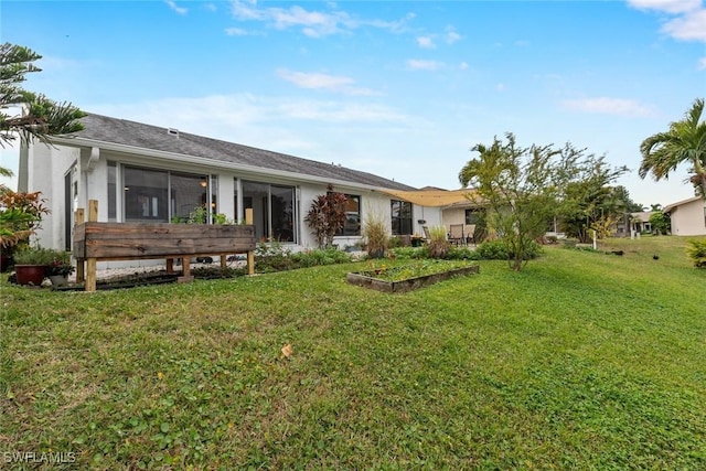 rear view of property featuring a lawn