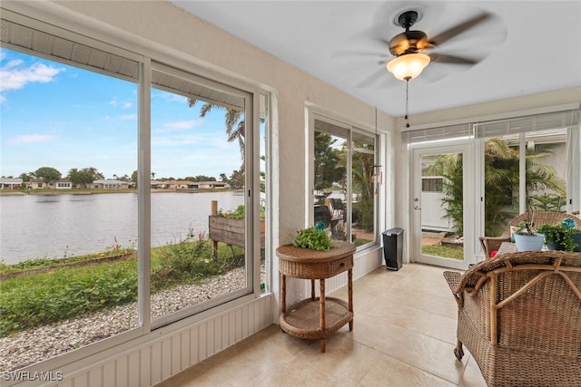 sunroom featuring a water view, ceiling fan, and plenty of natural light