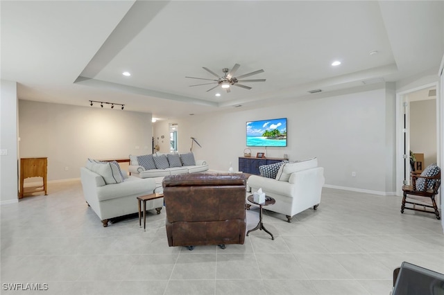 living room featuring ceiling fan, light tile patterned floors, a tray ceiling, and track lighting