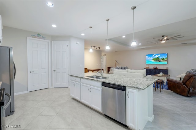 kitchen featuring light stone countertops, white cabinets, stainless steel appliances, sink, and hanging light fixtures