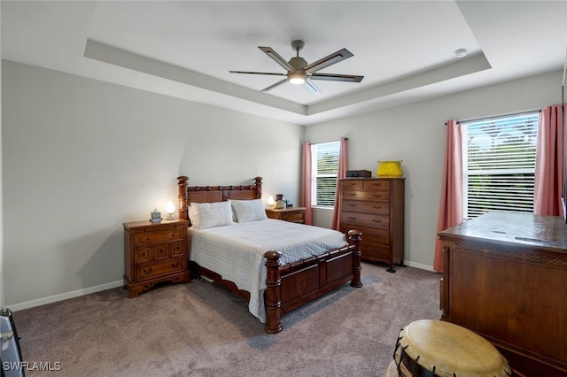 bedroom featuring light colored carpet, ceiling fan, and a raised ceiling