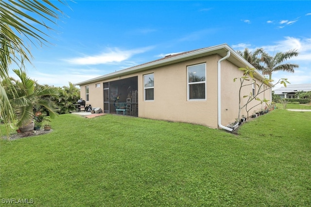 rear view of property featuring a lawn and a sunroom