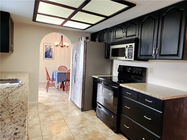 kitchen with light tile patterned floors, stainless steel appliances, and a chandelier