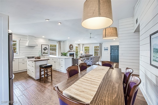 dining room featuring hardwood / wood-style flooring and wooden walls