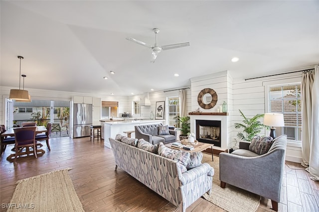 living room featuring ceiling fan, dark wood-type flooring, and lofted ceiling