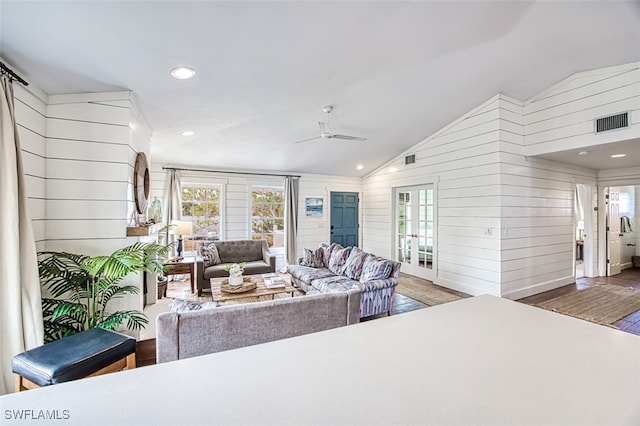 living room with lofted ceiling, ceiling fan, dark wood-type flooring, and wooden walls