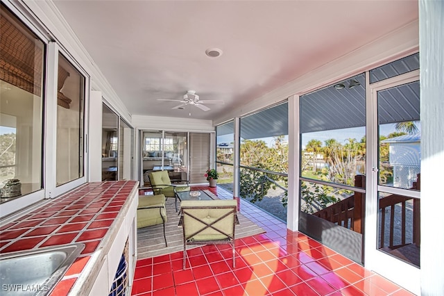 unfurnished sunroom with ceiling fan and sink