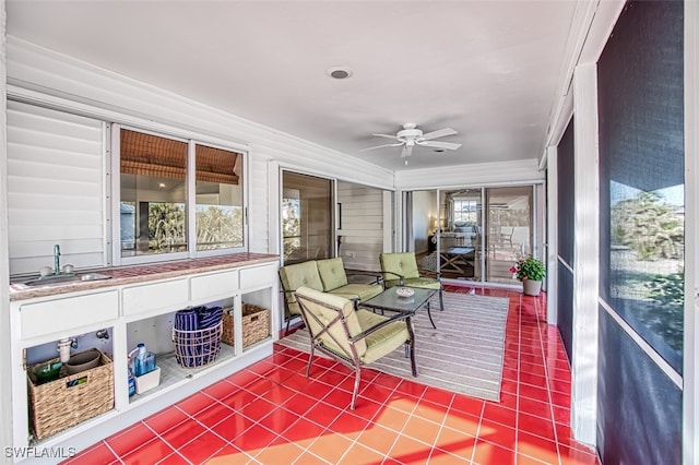 sunroom / solarium featuring ceiling fan and sink