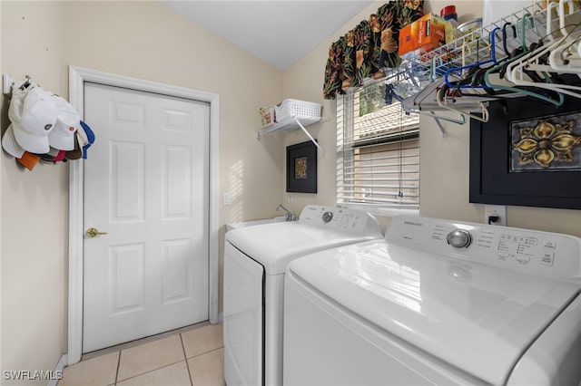 clothes washing area featuring washing machine and dryer and light tile patterned flooring