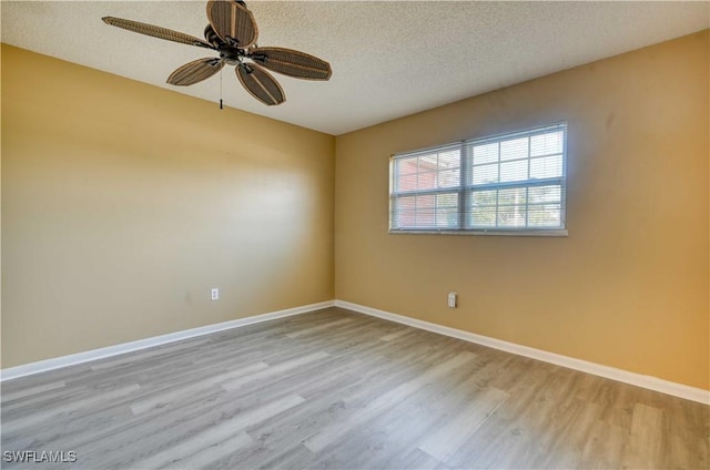 unfurnished room with ceiling fan, a textured ceiling, and light wood-type flooring