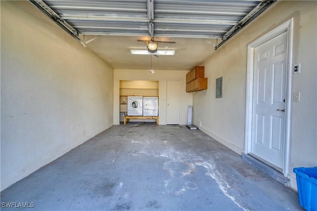 garage featuring washing machine and clothes dryer, a garage door opener, and electric panel