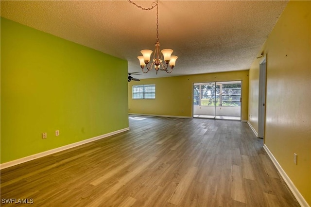 unfurnished room with hardwood / wood-style flooring, a textured ceiling, and a notable chandelier