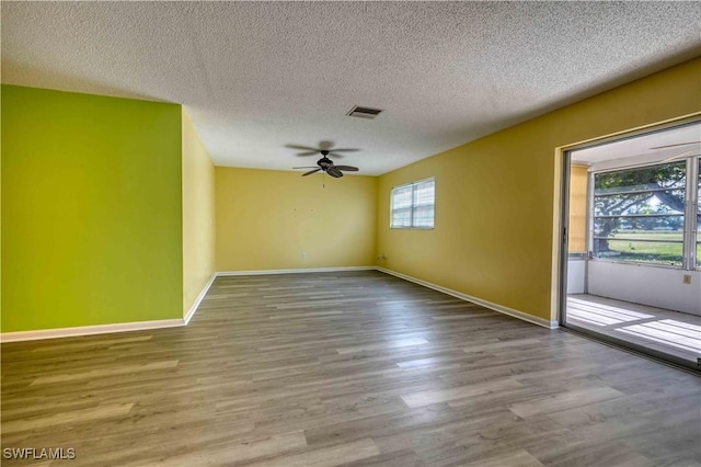 empty room with hardwood / wood-style floors, a textured ceiling, and ceiling fan