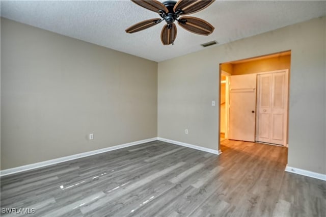 unfurnished room with ceiling fan, hardwood / wood-style flooring, and a textured ceiling